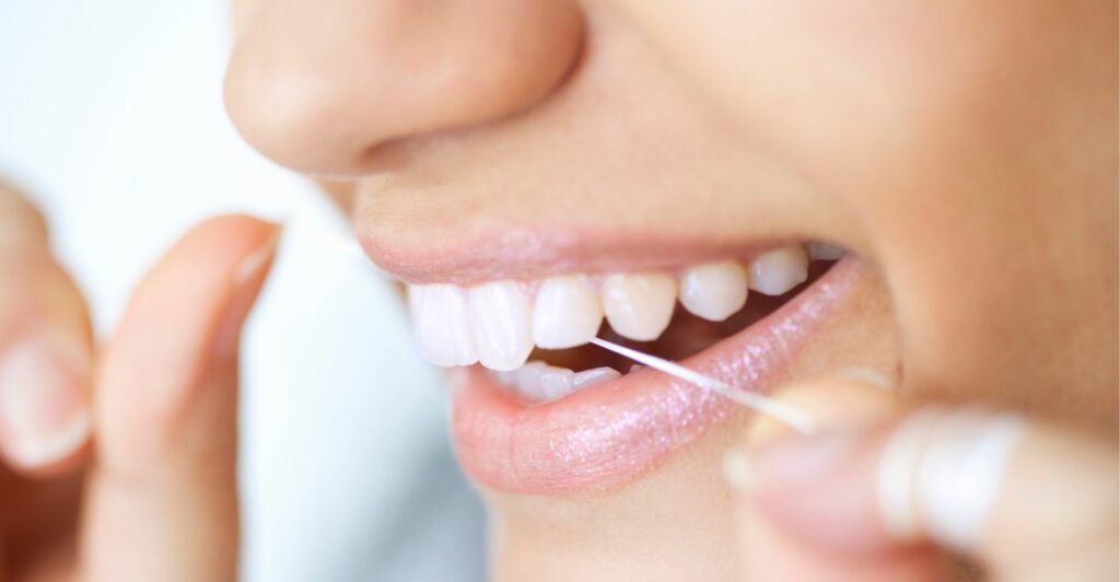 Woman flossing her teeth